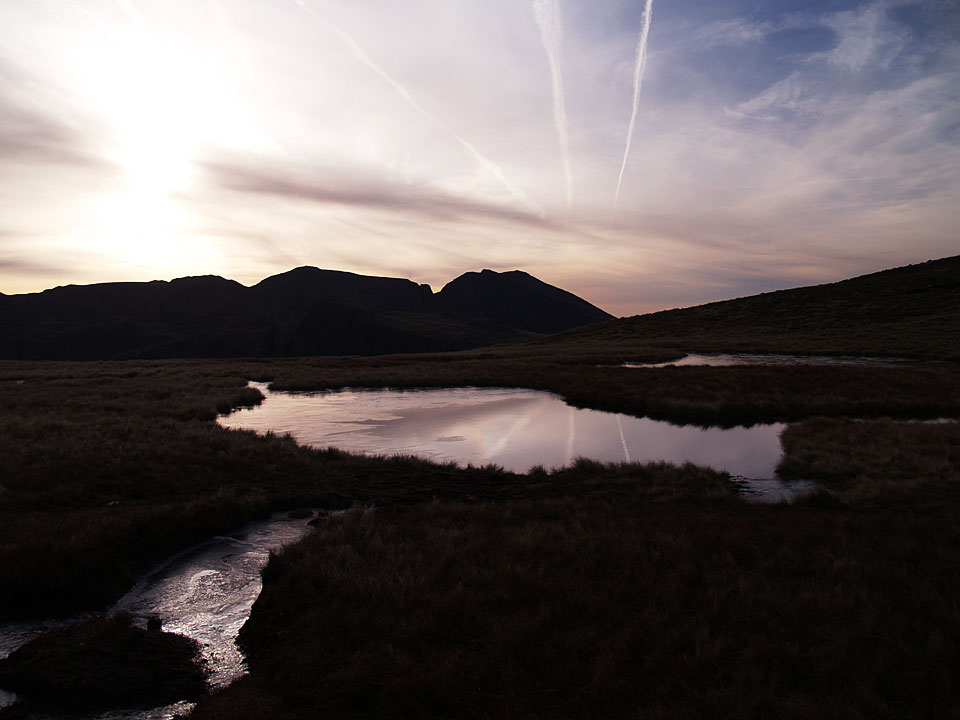 Scafell and Scafell Pike with the rising sun across Kirkfell Tarn